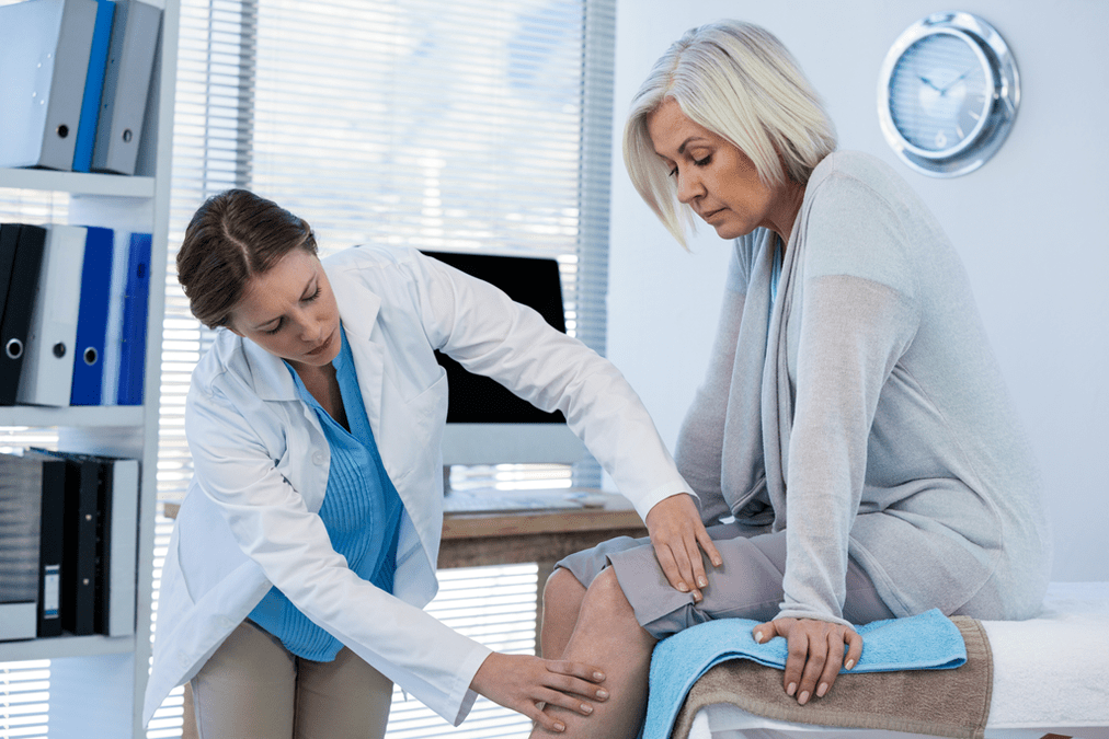 Un paciente con osteoartritis que necesita terapia es atendido por un médico.